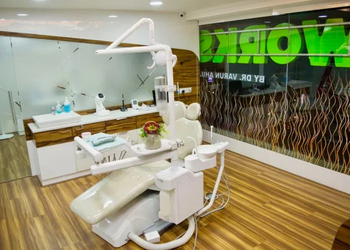 Treatment chair in front of the Tooth Works window sign at night